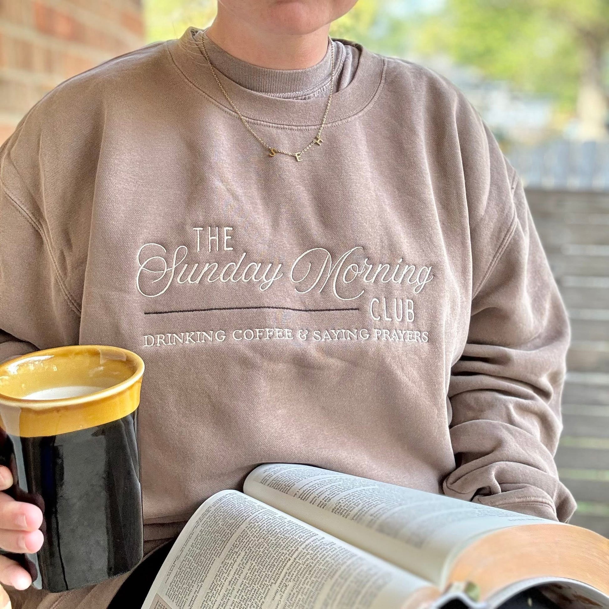 Woman wearing Sunday Morning Club graphic sweatshirt